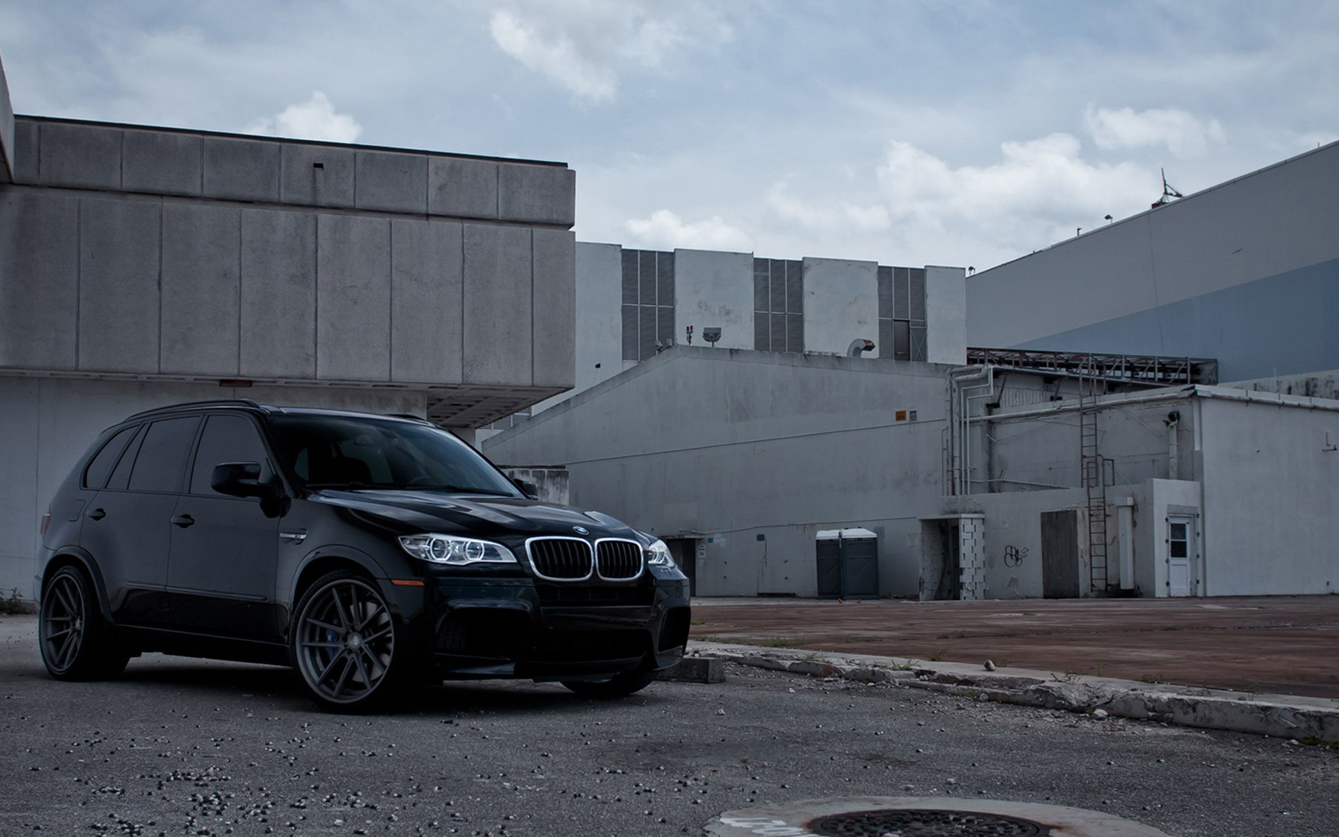Черный BMW X5 у заброшенного здания